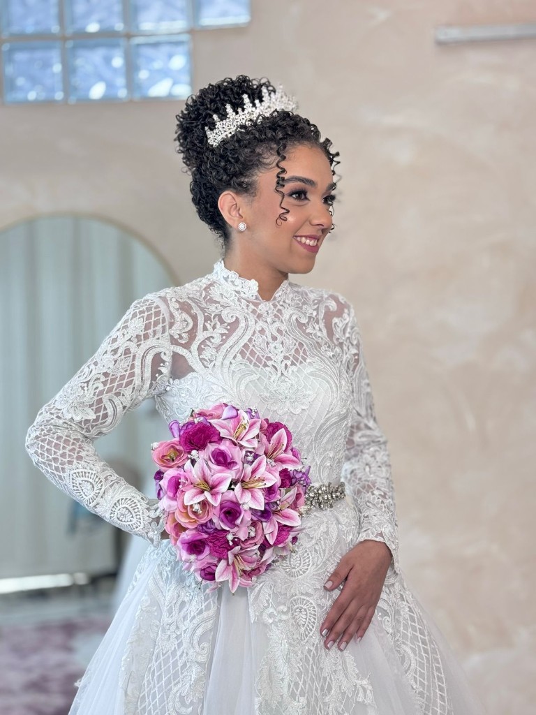 Noiva Ana Luiza de robe branco ao lado do vestido de renda no making of do casamento