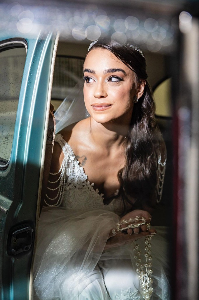 Noiva Giovanna com vestido tomara que caia, buquê de copos-de-leite e lustre de cristal