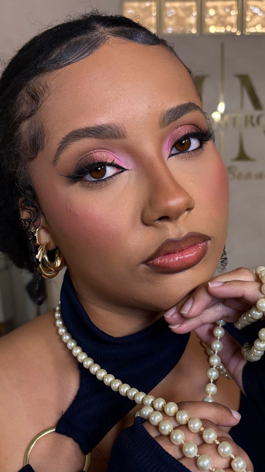 Retrato em estúdio com maquiagem glam: cut crease rosa e dourado, pele luminosa e lábios glossy.
